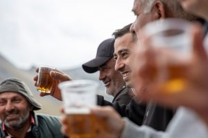 group of men drinking alcohol from plastic cups