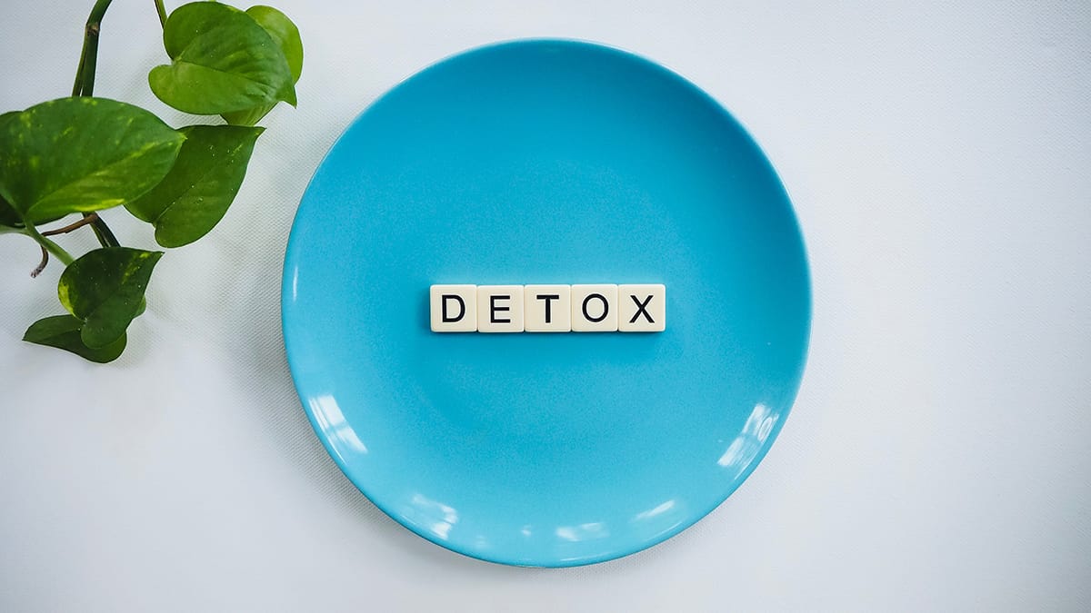 a blue plate with scrabble letters spelling out "detox"