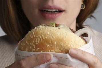 woman holding a burger close to her mouth