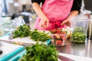 woman wearing apron, preparing fresh food at home