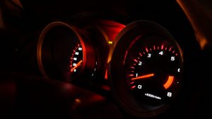 car dashboard at night showing the speedometers