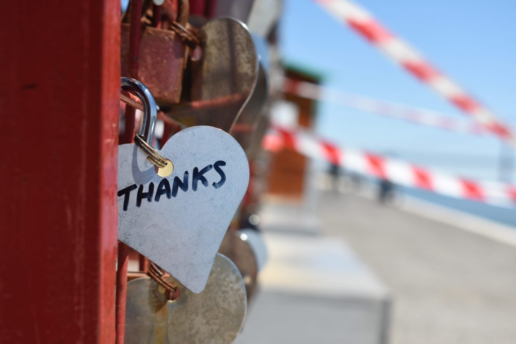 silver keychain with the words "thanks" locked on a bridge