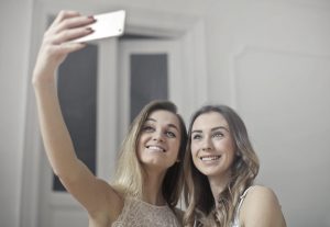 couple of women taking a selfie on a mobile phone