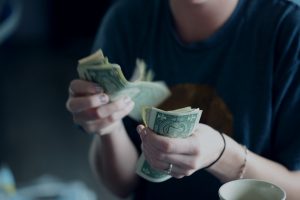 woman counting american notes in her hands