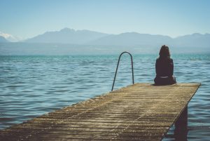 Woman sitting at the edge of a pier