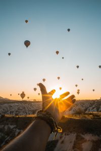 Man holding his hands out to balloon.