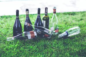 6 empty wine bottles on the grass