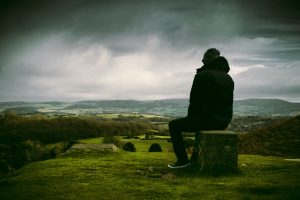 Man reflecting on a hill top